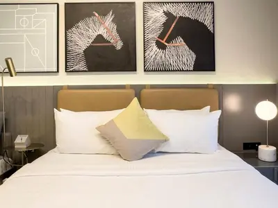 a bedroom with a bed with two pictures of horses on the wall at Cozy Studio in Business Bay in Dubai