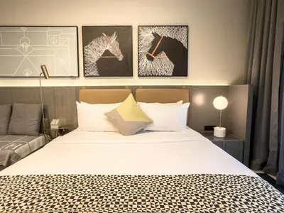 a bedroom with a bed and some pictures on the wall at Cozy Studio in Business Bay in Dubai