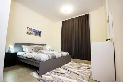 a bedroom with a bed and a large window at Newly furnished brand new 1BHK in Al Warsan in Dubai