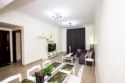 a living room with a couch and a table at Newly furnished brand new 1BHK in Al Warsan in Dubai