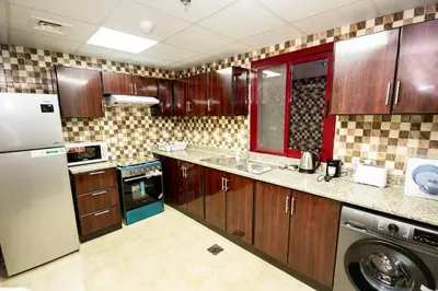 a kitchen with wooden cabinets and a washer at Newly furnished brand new 1BHK in Al Warsan in Dubai