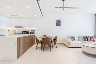 a kitchen and living room with a table and chairs at Exquisite Brand New Home in the heart of JVC in Dubai
