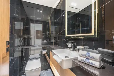 a bathroom with a sink and a toilet and a mirror at Exquisite Brand New Home in the heart of JVC in Dubai