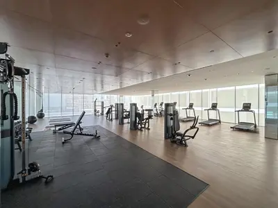 a gym with a lot of chairs and a lot of windows at Exquisite Brand New Home in the heart of JVC in Dubai