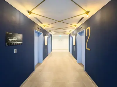 a hallway with blue walls and a hallway with a number on the wall at Collective Chic 1BR 15mins to Downtown Dubai Mall Beaches in Dubai