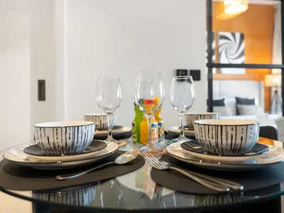 a glass table with plates and wine glasses on it at Collective Chic 1BR 15mins to Downtown Dubai Mall Beaches in Dubai