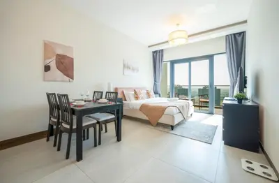 a bedroom with a bed and a table and chairs at Cozy Studio Pool & Gym Near Burj Khalifa & Racecourse views in Dubai