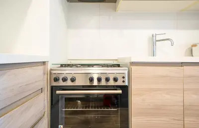 a kitchen with a stove top oven in a kitchen at Cozy Studio Pool & Gym Near Burj Khalifa & Racecourse views in Dubai