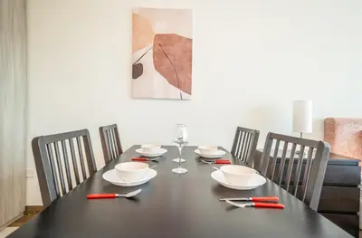 a dining room table with a black table and chairs at Cozy Studio Pool & Gym Near Burj Khalifa & Racecourse views in Dubai