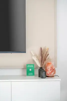 a table with a tv and a box on it at New Family-Friendly 2BR with Gym and Pool and Sauna in Dubai