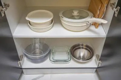 a cabinet filled with plates and bowls and a sink at New Family-Friendly 2BR with Gym and Pool and Sauna in Dubai