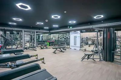 a gym with a bunch of treadmills and machines at New Family-Friendly 2BR with Gym and Pool and Sauna in Dubai