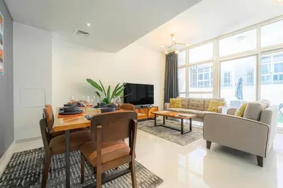 a living room with a table and a couch at Cozy 2BR Villa in Damac Hills 2 by deleguest in Dubai