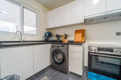 a kitchen with a washing machine and a sink at Cozy 2BR Villa in Damac Hills 2 by deleguest in Dubai