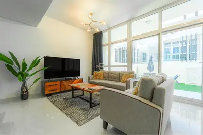 a living room with two couches and a flat screen tv at Cozy 2BR Villa in Damac Hills 2 by deleguest in Dubai