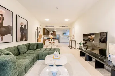 a living room with a green couch and a tv at Fabulous 1BR in Dubai Marina near Beach With Sea Views in Dubai