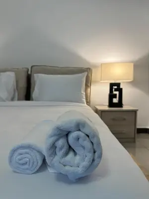 a bed with a blue towel laying on it at Swarg Stay in heart of Dubai in JVC in Dubai