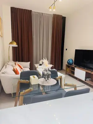 a living room with a couch and a tv at Elegant 1BR Apt in JVC Dubai with Spacious Balcony & City Views in Dubai