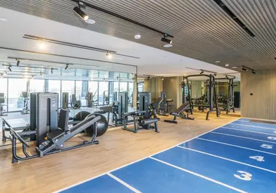 a gym with treadmills and cardio equipment in a building at Spacious 3BR Apartment in JVC Dubai Modern & Cozy Stay in Dubai