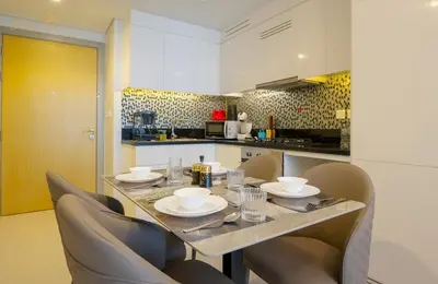 a kitchen with a table and chairs in a kitchen at Modern Sunset View 2Bhk 6pax in Dubai