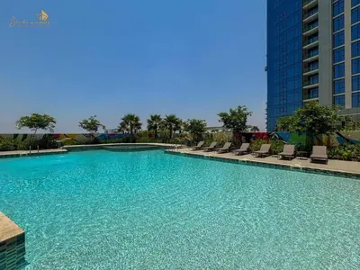 a large swimming pool with chairs and a building at Modern Sunset View 2Bhk 6pax in Dubai