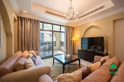 a living room with two couches and a television at Souk Al Bahar - Burj Khalifa - Dream View Holiday Home Rental in Dubai