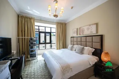 a bedroom with a large bed and a television at Souk Al Bahar - Burj Khalifa - Dream View Holiday Home Rental in Dubai