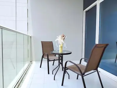 a table with three chairs and a vase on it at Burj View 2BR Near Dubai Mall Fast Wi-Fi Balcony in Dubai