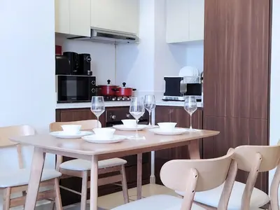 a table with wine glasses and chairs in a kitchen at Burj View 2BR Near Dubai Mall Fast Wi-Fi Balcony in Dubai