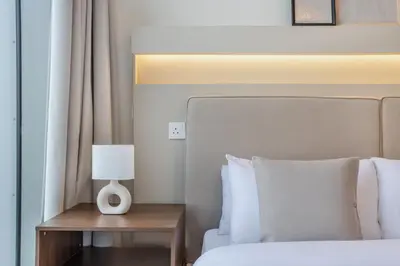a bedroom with a bed and a table with a lamp at High Floor Apartment with full Burj Khalifa View, Opera & Fountain - Downtown Dubai - Forte Tower by Stayfinity in Dubai
