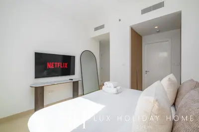 a living room with a bed and a tv at LUX The Orchid Creek Beach Suite in Dubai