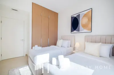 a bedroom with two beds and a couch in it at LUX The Orchid Creek Beach Suite in Dubai
