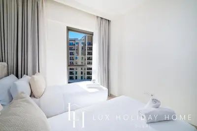 a living room with a white couch and a window at LUX The Orchid Creek Beach Suite in Dubai