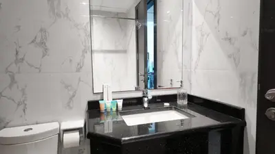 a bathroom with a sink and a mirror and a toilet at High Floor - Bright Elite Studio in Business Bay in Dubai