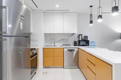 a kitchen with white cabinets and a stainless steel refrigerator at Spacious Dubai Marina 2BR Great Views Top Location in Dubai