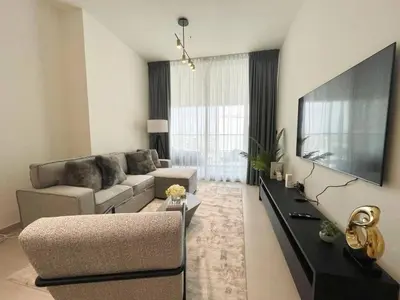 a living room with a couch and a flat screen tv at Brand New Cozy 2br Apartment In Jvc With Balcony in Dubai