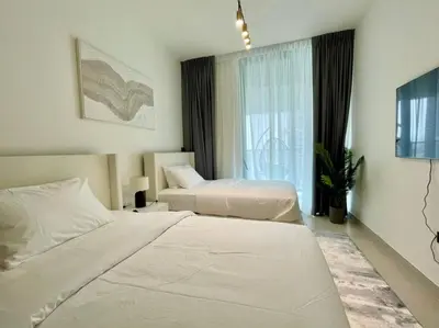 a hotel room with two beds and a window at Brand New Cozy 2br Apartment In Jvc With Balcony in Dubai