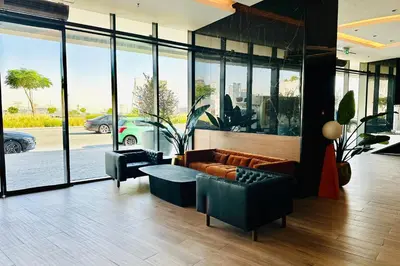 a living room with a couch and a table and windows at Vserve 1 BR Stay with Stunning Skyline Views in Dubai
