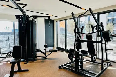 a gym with cardio equipment in a room with windows at Vserve 1 BR Stay with Stunning Skyline Views in Dubai
