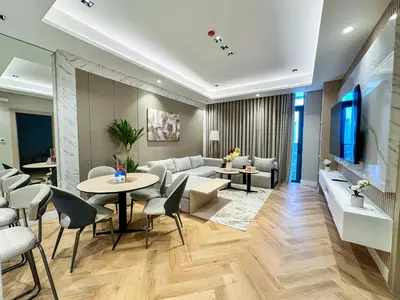 a living room with a couch and a table and chairs at Vserve 1 BR Stay with Stunning Skyline Views in Dubai