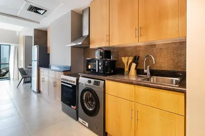 a kitchen with a sink and a washing machine at Stylish JLT Studio Lake View PoolMarina Walk in Dubai