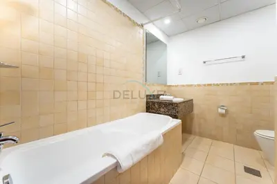 a bathroom with a tub and a sink and a toilet at Close to Major Landmarks 3BR and Assistant Room with Marina Views, Rimal 5, JBR by Deluxe Holiday Homes in Dubai