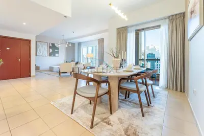 a dining room and living room with a table and chairs at Close to Major Landmarks 3BR and Assistant Room with Marina Views, Rimal 5, JBR by Deluxe Holiday Homes in Dubai