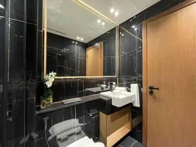 a black bathroom with a sink and a mirror at Premium 2br Apartment With Private Pool In Jvc in Dubai
