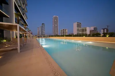 a swimming pool with a city skyline in the background at Premium 2br Apartment With Private Pool In Jvc in Dubai