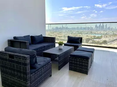 a balcony with wicker furniture and a view of the city at Premium 2br Apartment With Private Pool In Jvc in Dubai