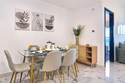 a dining room with a glass table and chairs at Family-Friendly 2BR Apartment in Dubai South at MAG-565 near EXPO and Al Maktoum Airport DWC in Dubai