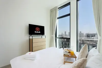 a hotel room with a bed and a large window at Livbnb-Urban Getaway 1BHK with JVC Skyline View in Dubai