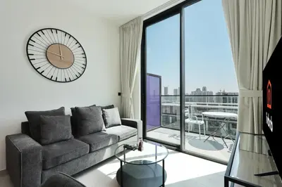 a living room with a couch and a large window at Livbnb-Urban Getaway 1BHK with JVC Skyline View in Dubai