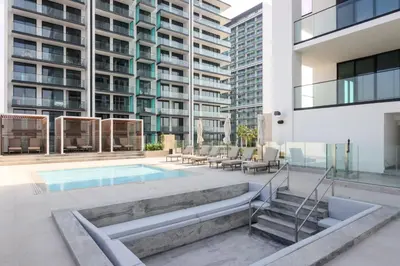 an apartment patio with a swimming pool and a building at Livbnb-Urban Getaway 1BHK with JVC Skyline View in Dubai